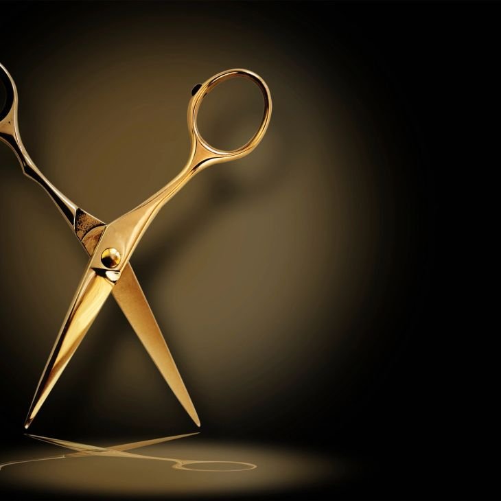 Gold hair shears against a dark background